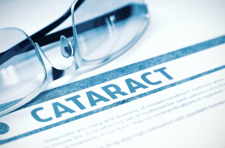 pair of eye glasses on a piece of paper that reads "cataract"