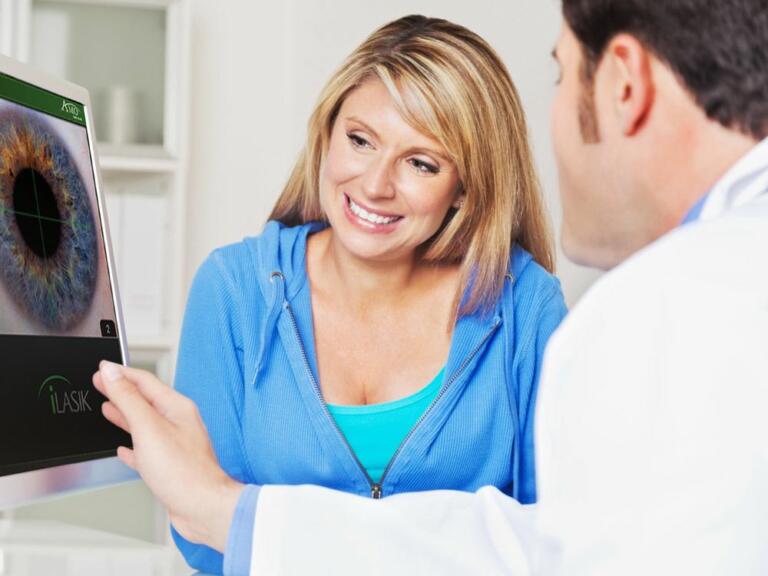 Lasik surgeon explaining LASIK procedure to patient.