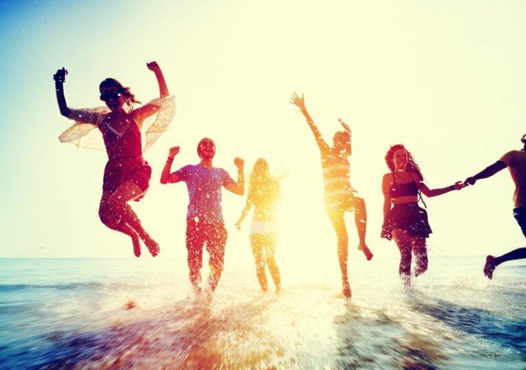 group of people splashing in the water at the beach