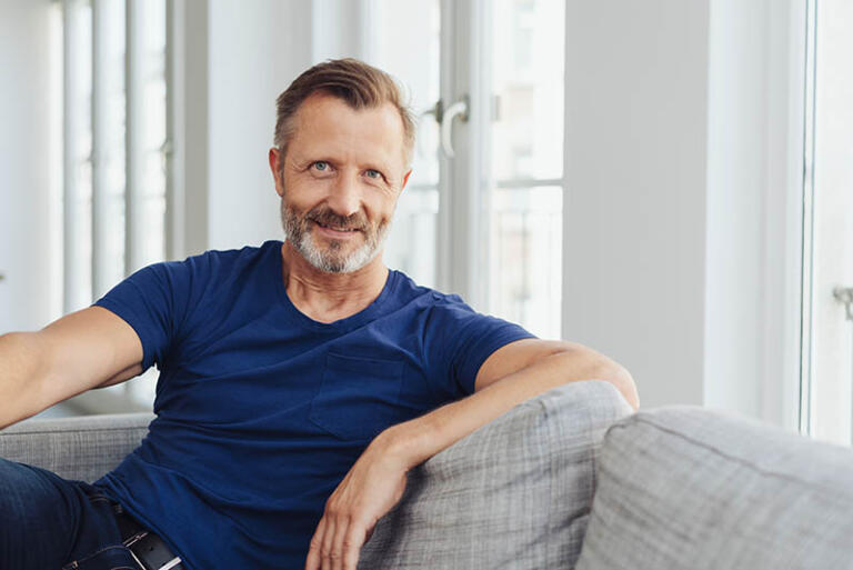 middle ages man sitting on a couch smiling