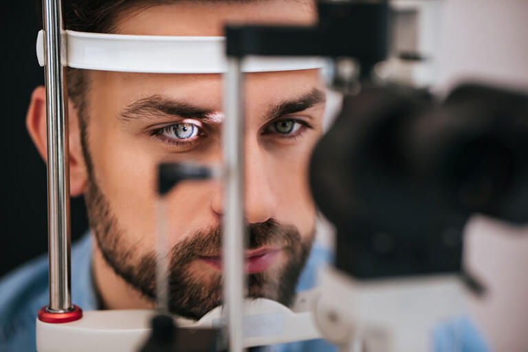 Patient in ophthalmology clinic having his eyes examined by eye doctor