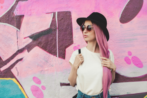 Stylish young woman with pink hair and a hat