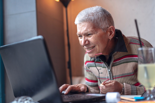 Older woman squinting, looking at a computer screen