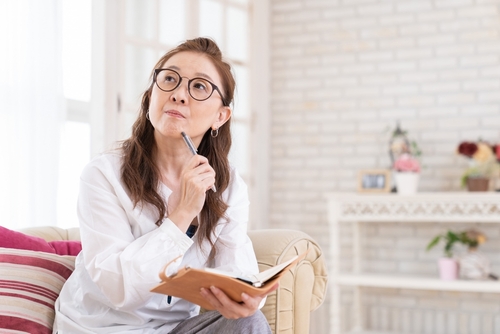 Woman with a schedule book and pen thinking