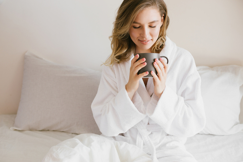 Woman in bath robe enjoying a warm drink