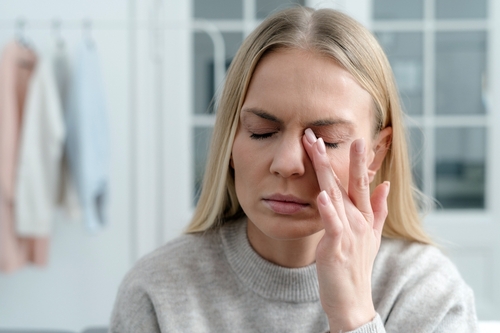 Woman rubbing her dry eyes