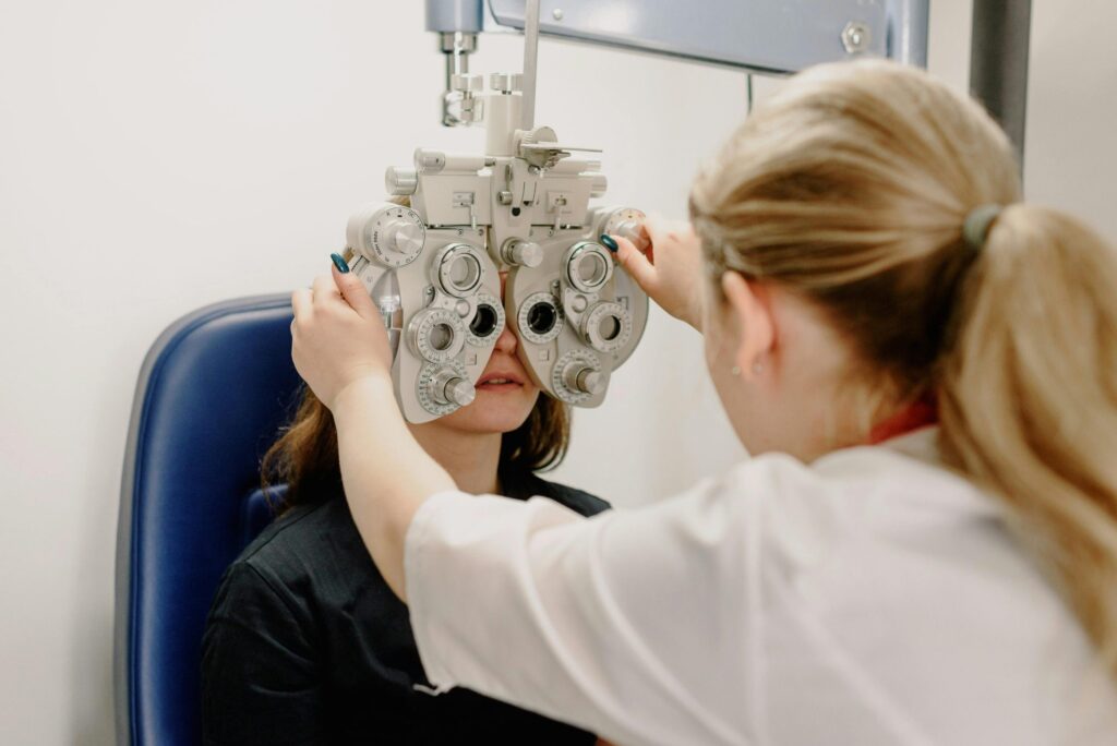 Optometrist positioning a phoropter for a vision test