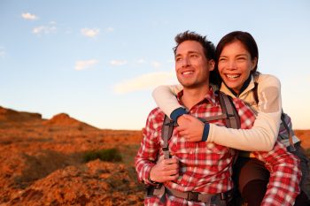 Couple in the San Francisco Bay Area smiles enjoying the sunrise while hiking after having LASIK at LaserVue Eye Center