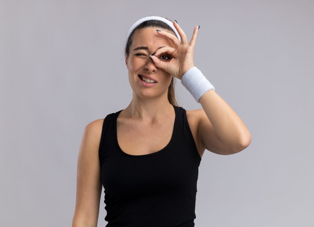 young pretty sporty woman wearing headband wristbands doing look gesture scaled.jpg