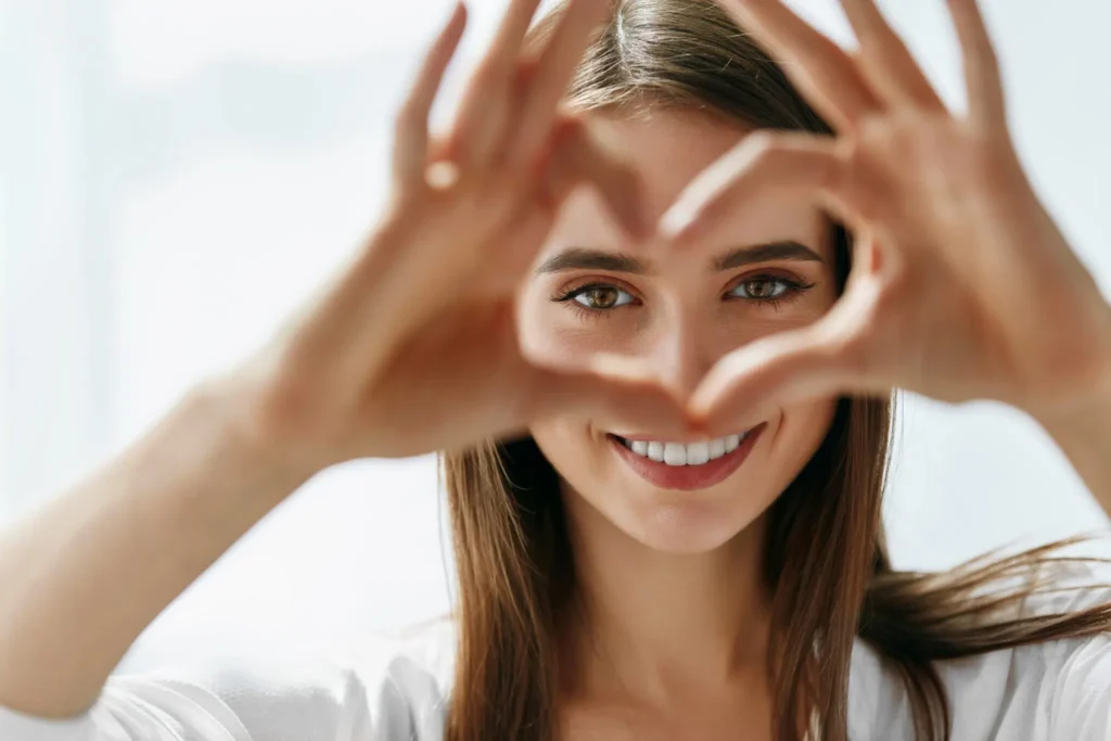 Young woman with a heart hand with her eyes in the center