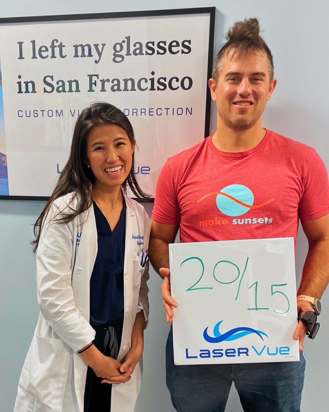 Luke I LASIK Patient at LaserVue Eye Center San Francisco, standing next to Dr. Stephanie Wangyu and holding a sign that reads "20/15. LaserVue." Poster behind reads "I left my glasses in San Francisco. Custom vision correction with LaserVue Eye Center."