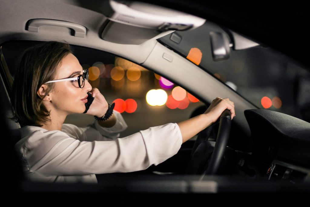 Woman driving a car at night with glare from oncoming lights