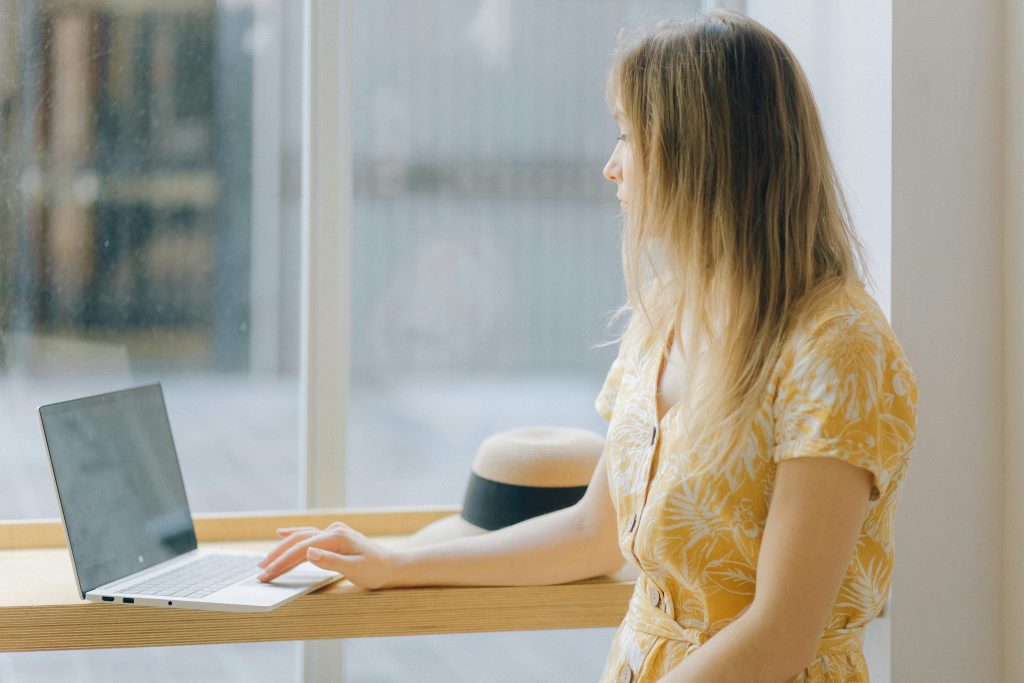 Woman working at a desk by a bright window