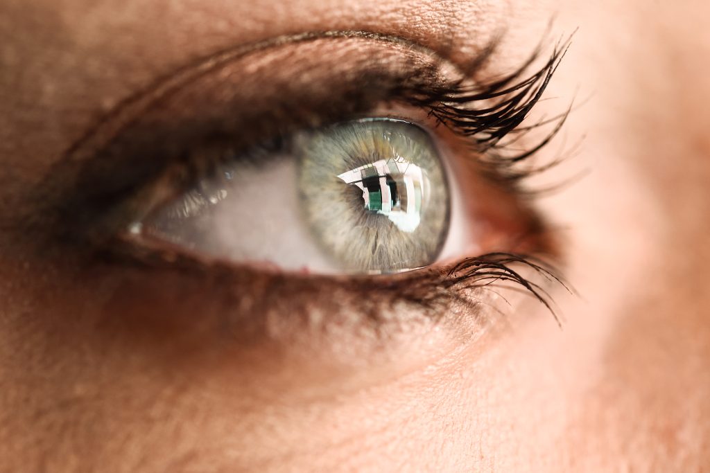 Close-up of a woman's green eye with long lashes