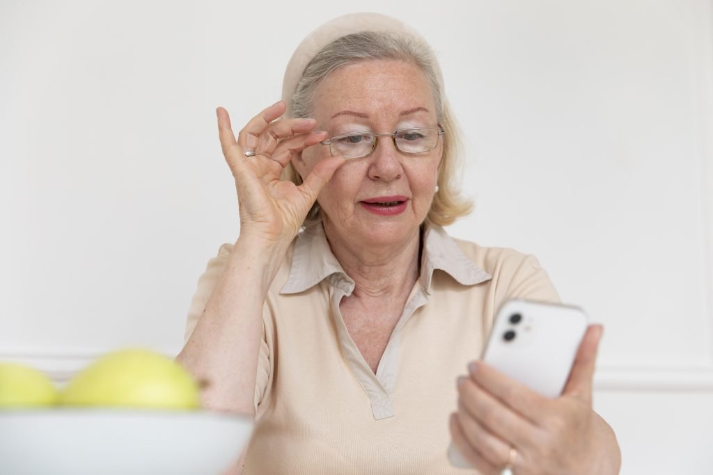 Senior woman peering over her glasses at a smartphone