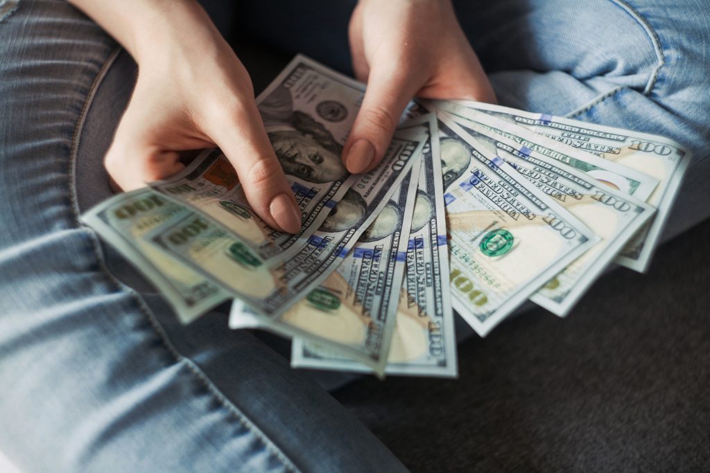 Hands fanning out hundred-dollar bills