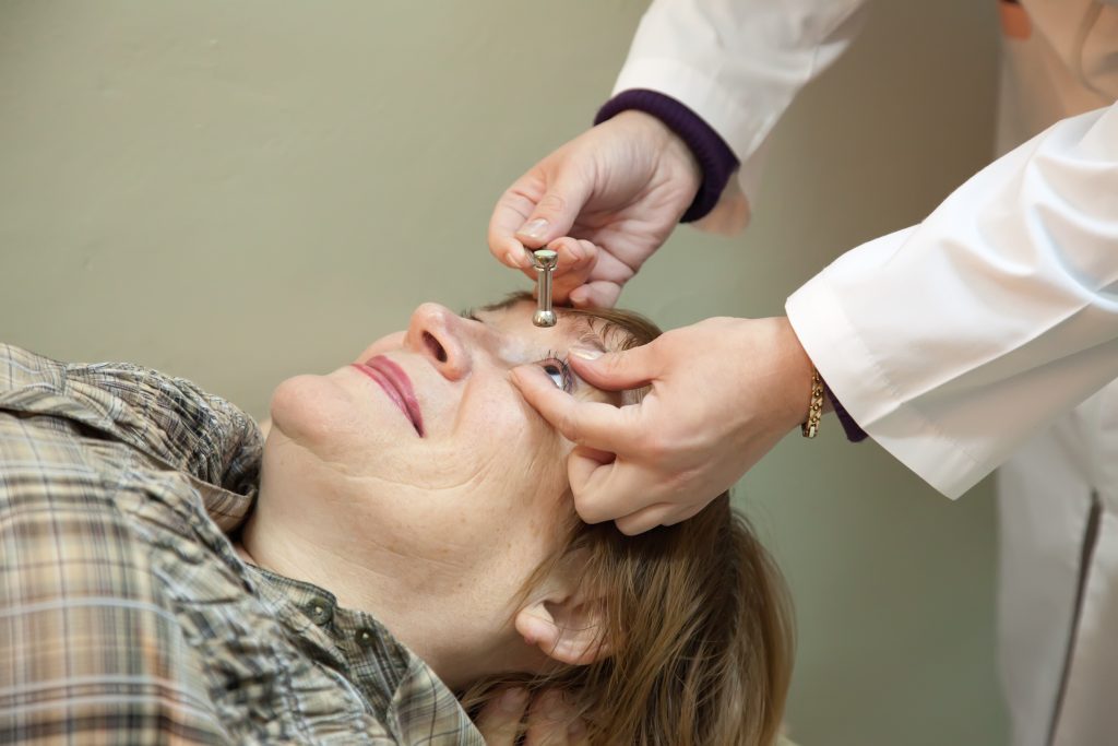 Eye doctor applying eye drops to a patient