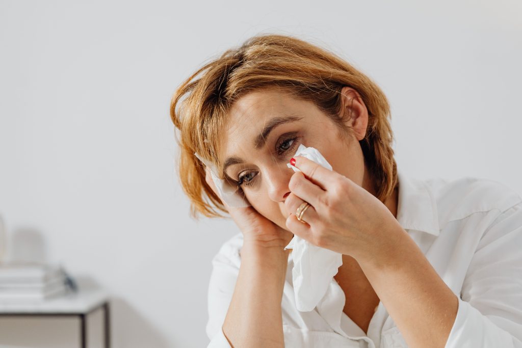 Woman dabbing her eye with a tissue