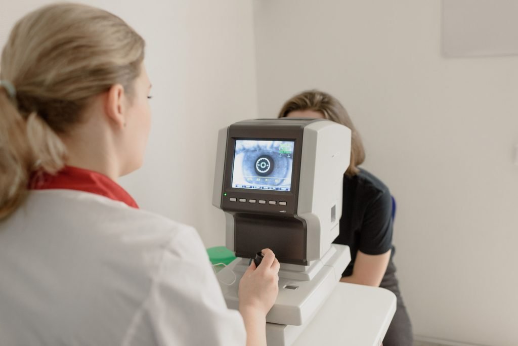 Eye care technician reviewing results on a diagnostic device