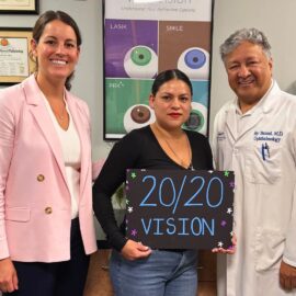 Celia C LASIK 20/20 vision patient standing with Dr. Jay Bansal and Dr. Francesca Sefton, holding a sign that reads "20 20 vision"